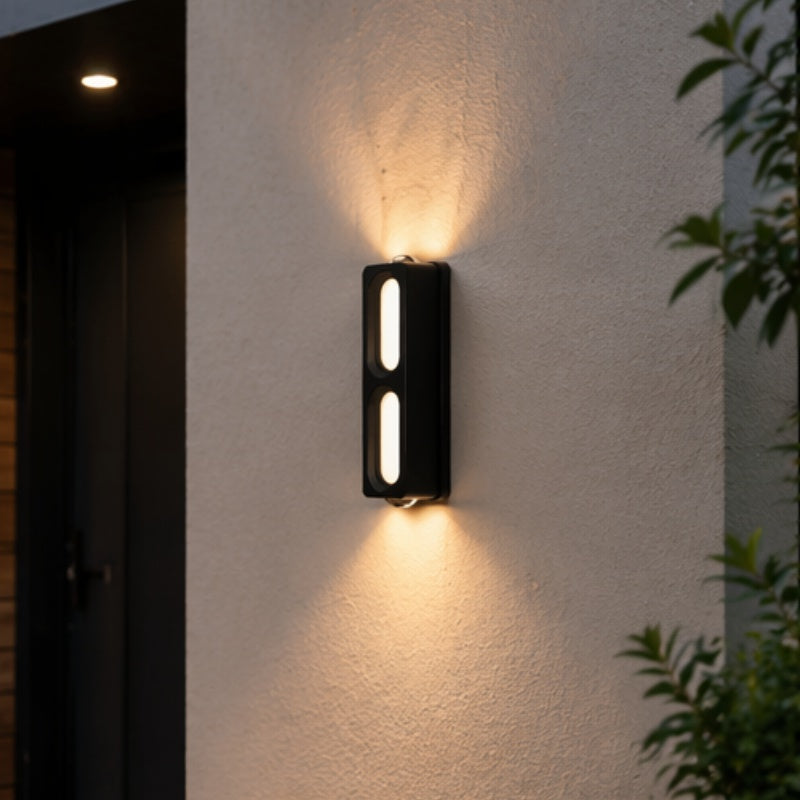 Two-window black LED wall light illuminating a textured exterior entrance wall with warm light